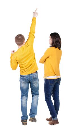 Back view of couple couple in sweater pointing. beautiful friendly girl and guy together. Rear view people collection. backside view of person. Isolated over white background.の写真素材