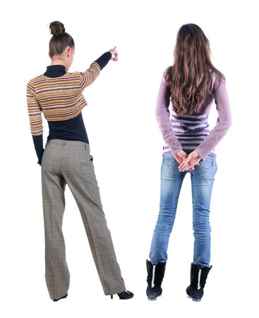 Back view of two pointing young girl in sweater. Rear view people collection. backside view of person. beautiful woman friends showing gesture. Rear view. Isolated over white background.の写真素材