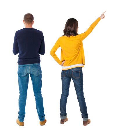 Back view of couple couple in sweater pointing. beautiful friendly girl and guy together. Rear view people collection. backside view of person. Isolated over white background.の写真素材