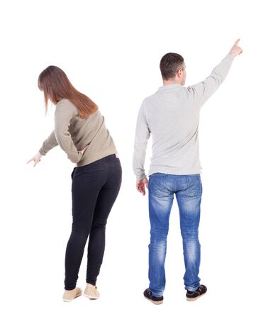 Back view of couple couple in sweater pointing. beautiful friendly girl and guy together. Rear view people collection. backside view of person. Isolated over white background.の写真素材