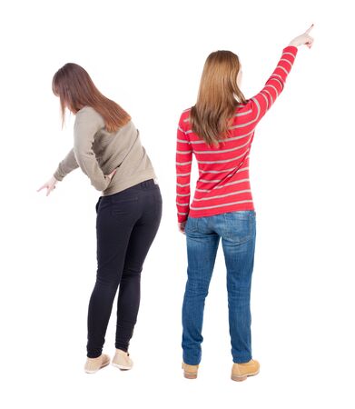 Back view of two pointing young girl in sweater. Rear view people collection. backside view of person. beautiful woman friends showing gesture. Rear view. Isolated over white background.の写真素材