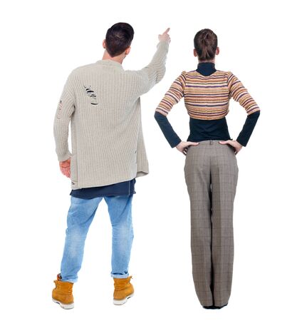 Back view of couple couple in sweater pointing. beautiful friendly girl and guy together. Rear view people collection. backside view of person. Isolated over white background.の写真素材