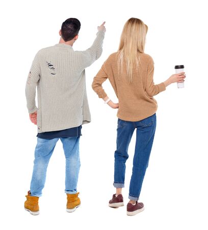 Back view of couple couple in sweater pointing. beautiful friendly girl and guy together. Rear view people collection. backside view of person. Isolated over white background.の写真素材