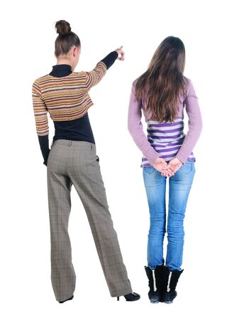 Back view of two pointing young girl in sweater. Rear view people collection. backside view of person. beautiful woman friends showing gesture. Rear view. Isolated over white background.の写真素材