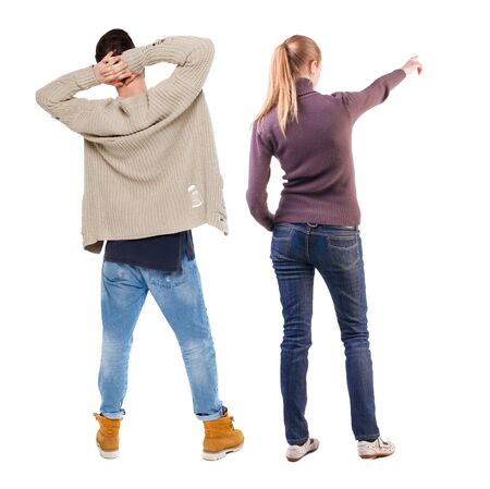 Back view of couple couple in sweater pointing. beautiful friendly girl and guy together. Rear view people collection. backside view of person. Isolated over white background.の写真素材