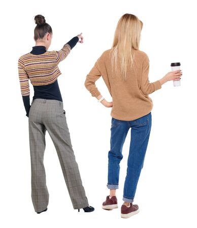 Back view of two pointing young girl in sweater. Rear view people collection. backside view of person. beautiful woman friends showing gesture. Rear view. Isolated over white background.の写真素材