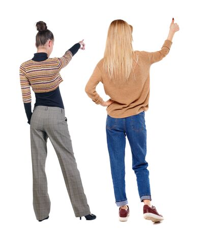 Back view of two pointing young girl in sweater. Rear view people collection. backside view of person. beautiful woman friends showing gesture. Rear view. Isolated over white background.の写真素材