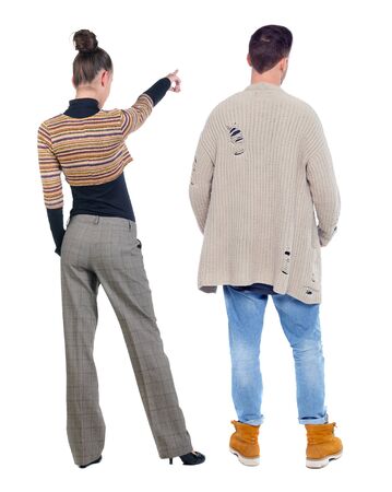 Back view of couple couple in sweater pointing. beautiful friendly girl and guy together. Rear view people collection. backside view of person. Isolated over white background.の写真素材