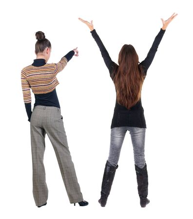 Back view of two pointing young girl in sweater. Rear view people collection. backside view of person. beautiful woman friends showing gesture. Rear view. Isolated over white background.の写真素材