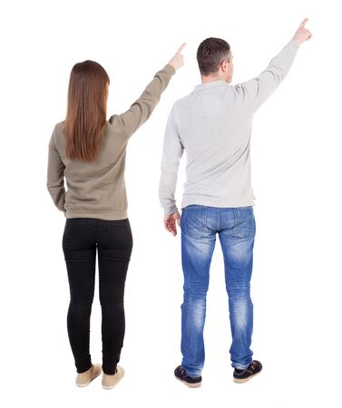 Back view of couple couple in sweater pointing. beautiful friendly girl and guy together. Rear view people collection. backside view of person. Isolated over white background.の写真素材