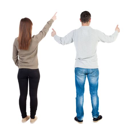 Back view of couple couple in sweater pointing. beautiful friendly girl and guy together. Rear view people collection. backside view of person. Isolated over white background.の写真素材