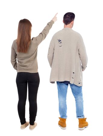 Back view of couple couple in sweater pointing. beautiful friendly girl and guy together. Rear view people collection. backside view of person. Isolated over white background.の写真素材
