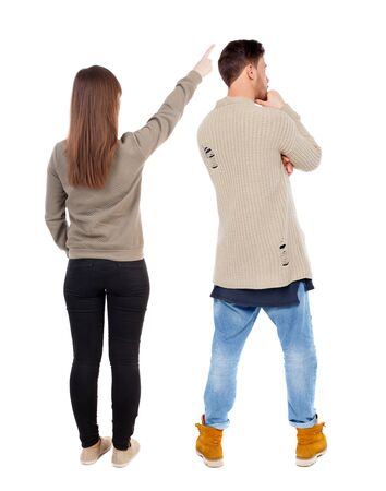 Back view of couple couple in sweater pointing. beautiful friendly girl and guy together. Rear view people collection. backside view of person. Isolated over white background.の写真素材