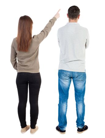 Back view of couple couple in sweater pointing. beautiful friendly girl and guy together. Rear view people collection. backside view of person. Isolated over white background.の写真素材