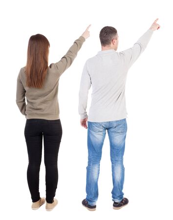 Back view of couple couple in sweater pointing. beautiful friendly girl and guy together. Rear view people collection. backside view of person. Isolated over white background.の写真素材