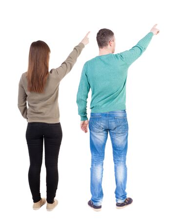 Back view of couple couple in sweater pointing. beautiful friendly girl and guy together. Rear view people collection. backside view of person. Isolated over white background.の写真素材