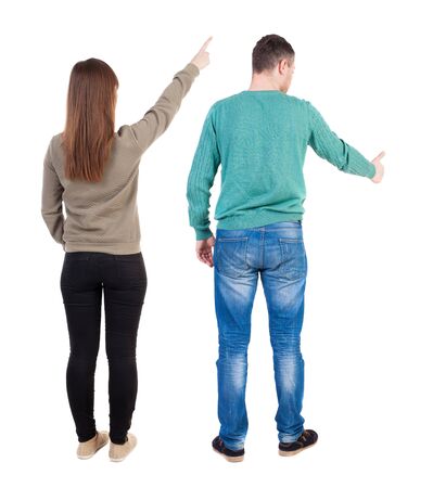 Back view of couple couple in sweater pointing. beautiful friendly girl and guy together. Rear view people collection. backside view of person. Isolated over white background.の写真素材