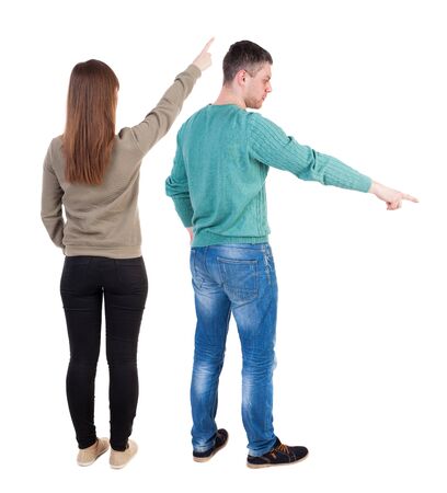 Back view of couple couple in sweater pointing. beautiful friendly girl and guy together. Rear view people collection. backside view of person. Isolated over white background.の写真素材