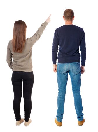 Back view of couple couple in sweater pointing. beautiful friendly girl and guy together. Rear view people collection. backside view of person. Isolated over white background.の写真素材