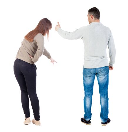 Back view of couple couple in sweater pointing. beautiful friendly girl and guy together. Rear view people collection. backside view of person. Isolated over white background.の写真素材