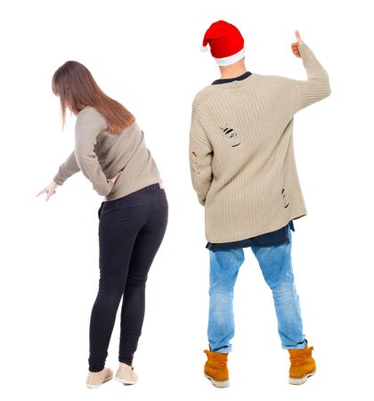 Back view of couple couple in sweater pointing. beautiful friendly girl and guy together. Rear view people collection. backside view of person. Isolated over white background.の写真素材