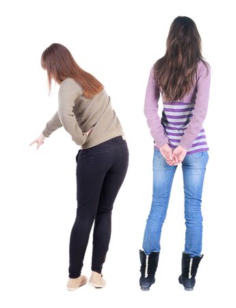 Back view of two pointing young girl in sweater. Rear view people collection. backside view of person. beautiful woman friends showing gesture. Rear view. Isolated over white background.の写真素材
