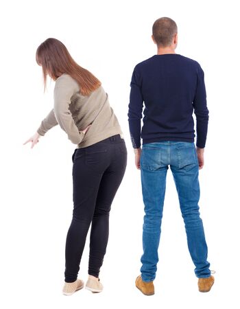 Back view of couple couple in sweater pointing. beautiful friendly girl and guy together. Rear view people collection. backside view of person. Isolated over white background.の写真素材