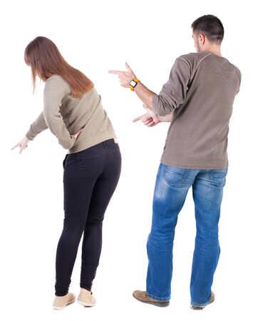 Back view of couple couple in sweater pointing. beautiful friendly girl and guy together. Rear view people collection. backside view of person. Isolated over white background.の写真素材