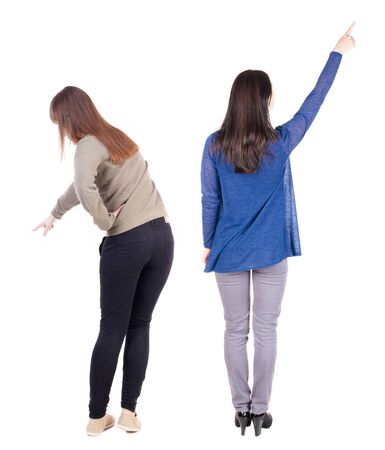 Back view of two pointing young girl in sweater. Rear view people collection. backside view of person. beautiful woman friends showing gesture. Rear view. Isolated over white background.の写真素材
