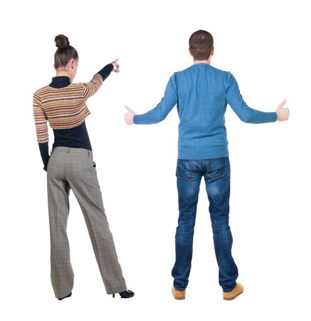 Back view of couple couple in sweater pointing. beautiful friendly girl and guy together. Rear view people collection. backside view of person. Isolated over white background.の写真素材