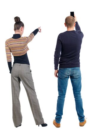 Back view of couple in sweater with mobile phone. beautiful friendly girl and guy together. Rear view people collection. backside view of person. Isolated over white background.の写真素材