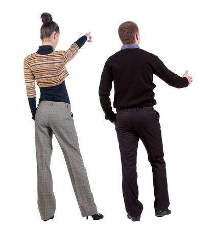 Back view of couple couple in sweater pointing. beautiful friendly girl and guy together. Rear view people collection. backside view of person. Isolated over white background.の写真素材