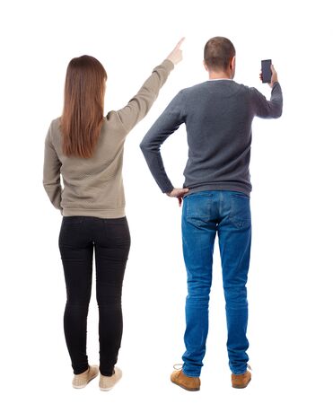 Back view of couple in sweater with mobile phone. beautiful friendly girl and guy together. Rear view people collection. backside view of person. Isolated over white background.の写真素材