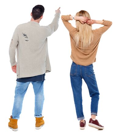 Back view of couple couple in sweater pointing. beautiful friendly girl and guy together. Rear view people collection. backside view of person. Isolated over white background.の写真素材