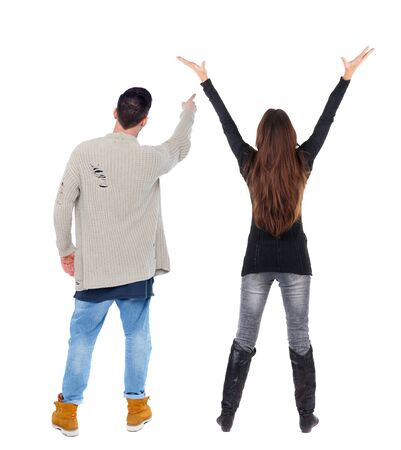 Back view of couple couple in sweater pointing. beautiful friendly girl and guy together. Rear view people collection. backside view of person. Isolated over white background.の写真素材