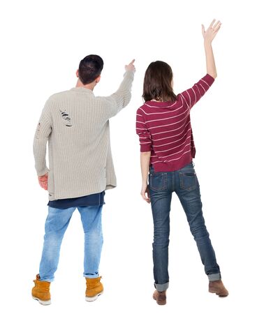 Back view of couple couple in sweater pointing. beautiful friendly girl and guy together. Rear view people collection. backside view of person. Isolated over white background.の写真素材