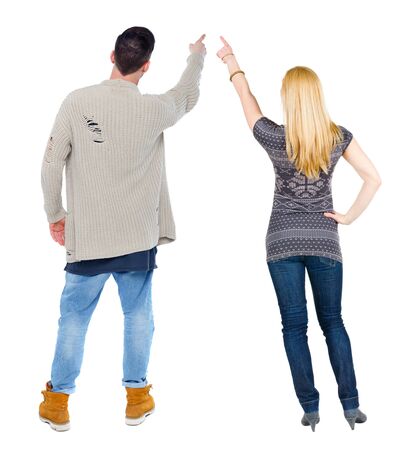 Back view of couple couple in sweater pointing. beautiful friendly girl and guy together. Rear view people collection. backside view of person. Isolated over white background.の写真素材