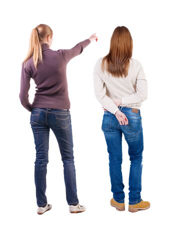 Back view of two pointing young girl in sweater. Rear view people collection. backside view of person. beautiful woman friends showing gesture. Rear view. Isolated over white background.の写真素材
