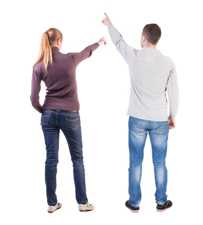 Back view of couple couple in sweater pointing. beautiful friendly girl and guy together. Rear view people collection. backside view of person. Isolated over white background.の写真素材