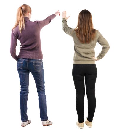 Back view of two pointing young girl in sweater. Rear view people collection. backside view of person. beautiful woman friends showing gesture. Rear view. Isolated over white background.の写真素材
