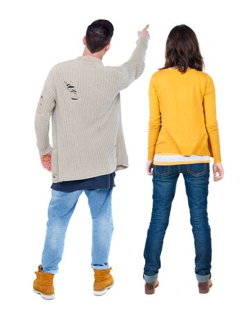 Back view of couple couple in sweater pointing. beautiful friendly girl and guy together. Rear view people collection. backside view of person. Isolated over white background.の写真素材