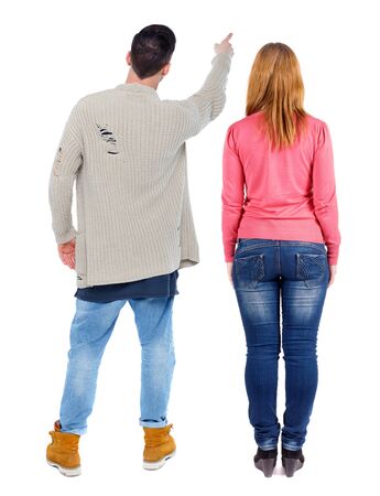 Back view of couple couple in sweater pointing. beautiful friendly girl and guy together. Rear view people collection. backside view of person. Isolated over white background.の写真素材