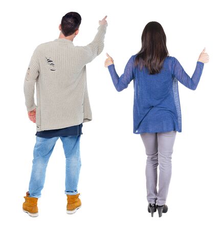 Back view of couple couple in sweater pointing. beautiful friendly girl and guy together. Rear view people collection. backside view of person. Isolated over white background.の写真素材