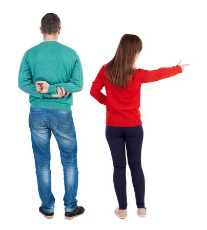 Back view of couple couple in sweater pointing. beautiful friendly girl and guy together. Rear view people collection. backside view of person. Isolated over white background.の写真素材