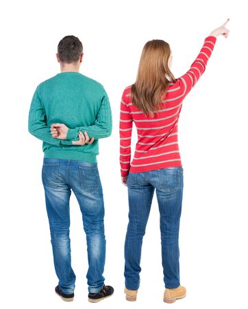 Back view of couple couple in sweater pointing. beautiful friendly girl and guy together. Rear view people collection. backside view of person. Isolated over white background.の写真素材
