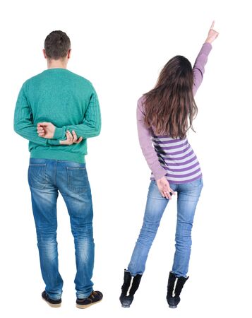 Back view of couple couple in sweater pointing. beautiful friendly girl and guy together. Rear view people collection. backside view of person. Isolated over white background.の写真素材