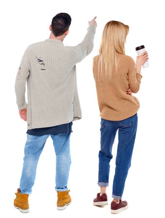 Back view of couple couple in sweater pointing. beautiful friendly girl and guy together. Rear view people collection. backside view of person. Isolated over white background.の写真素材