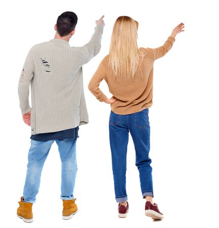 Back view of couple couple in sweater pointing. beautiful friendly girl and guy together. Rear view people collection. backside view of person. Isolated over white background.の写真素材