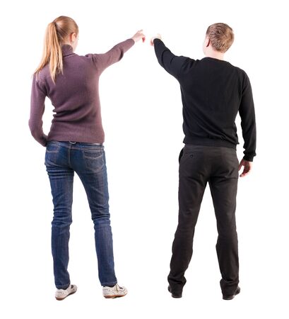 Back view of couple couple in sweater pointing. beautiful friendly girl and guy together. Rear view people collection. backside view of person. Isolated over white background.の写真素材