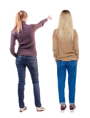 Back view of two pointing young girl in sweater. Rear view people collection. backside view of person. beautiful woman friends showing gesture. Rear view. Isolated over white background.の写真素材